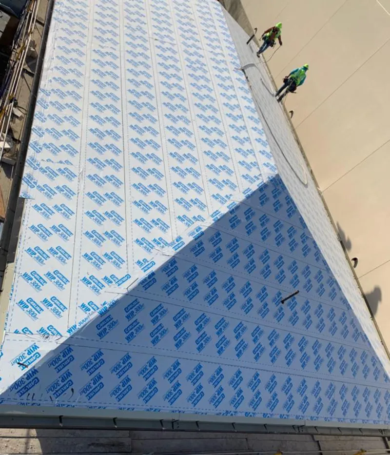 Professional roofers installing underlayment on a metal roof in O'Hara